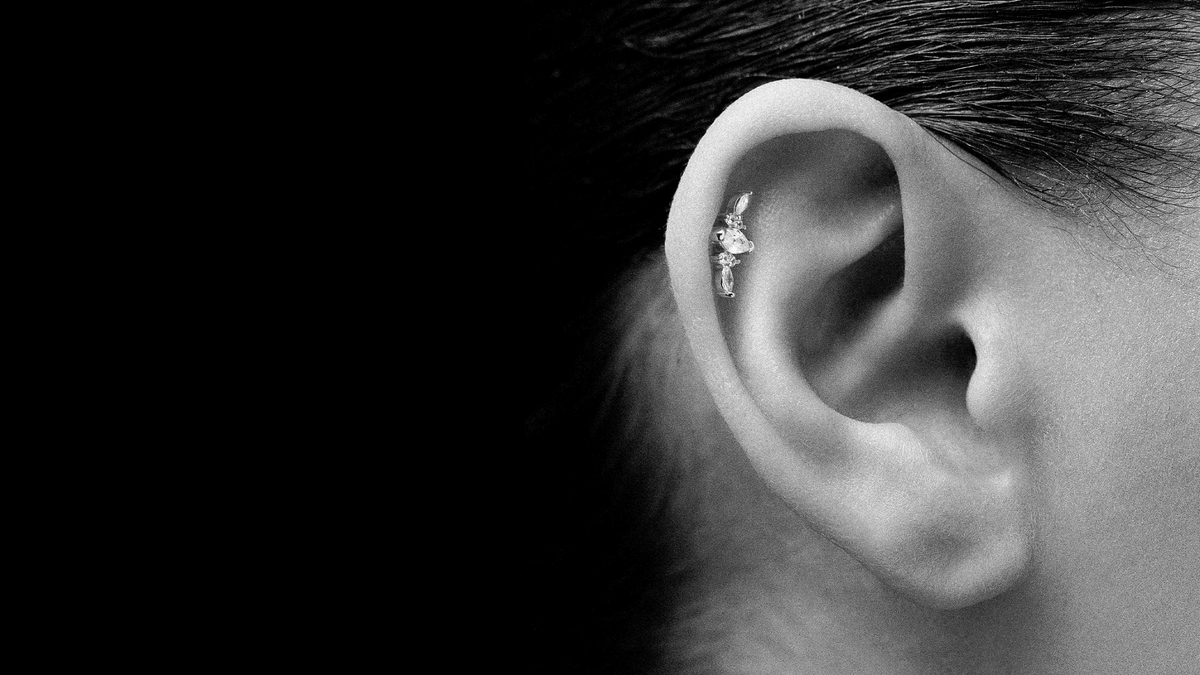 Oreille de femme avec un piercing à l'hélix