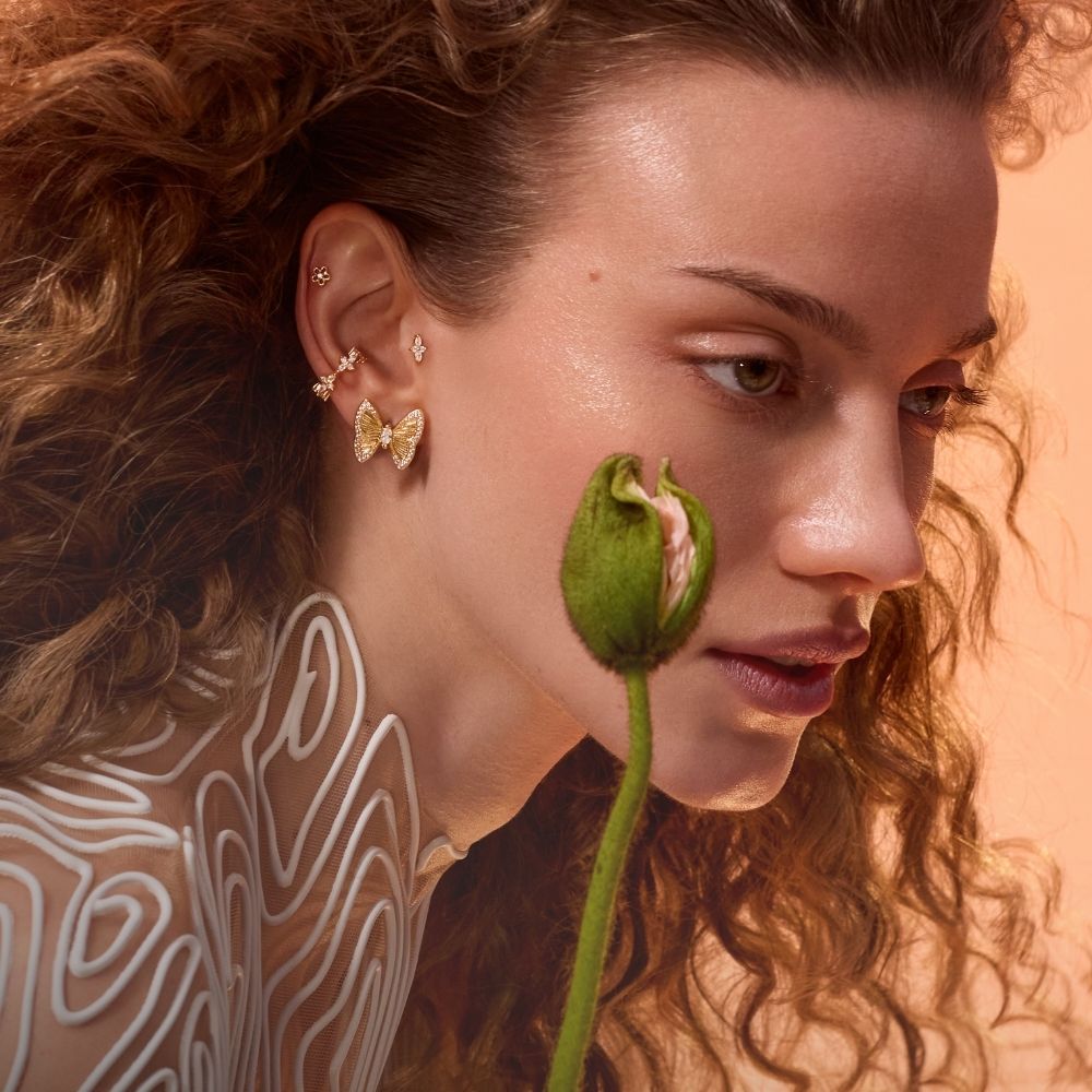 Femme aux cheveux bouclés portant un piercing boucle d'oreille papillon, collection Renaissance